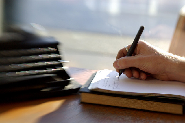credit-bond A Person Writing in a Notebook with a Pen
